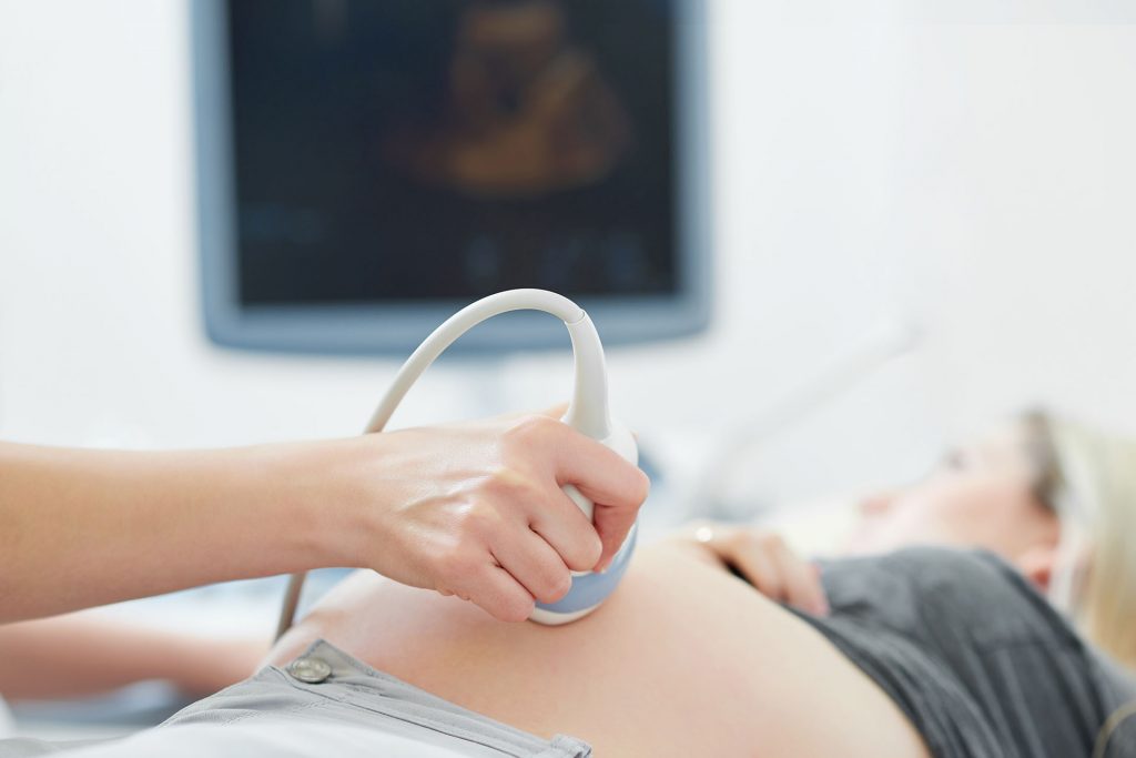 Médico realizando una ecografía a una embarazada